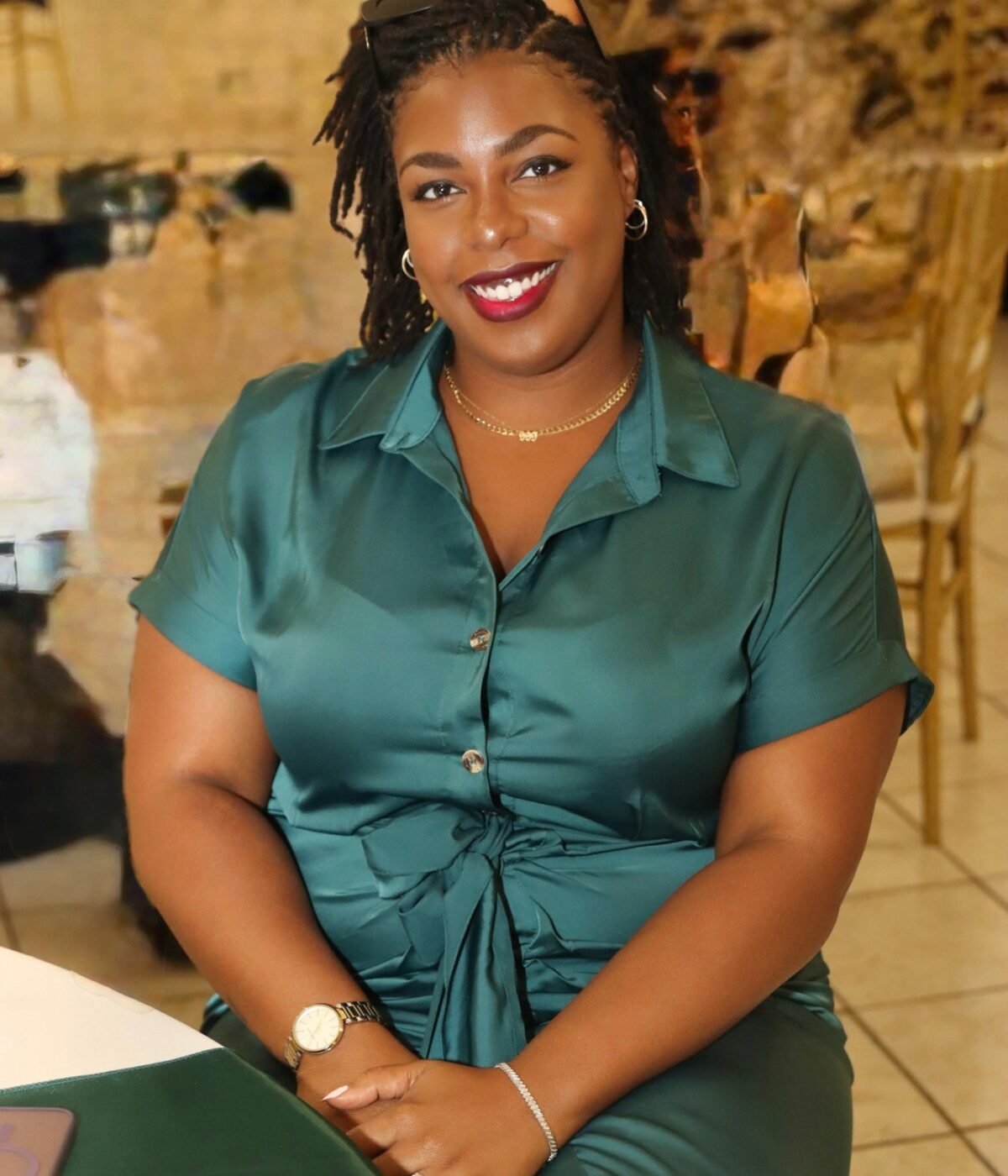 LAUNA smiling in a teal satin dress, her locs worn loose over her shoulders