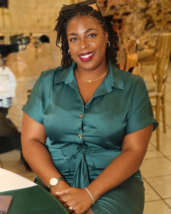 LAUNA smiling in a teal satin dress, her locs worn loose over her shoulders